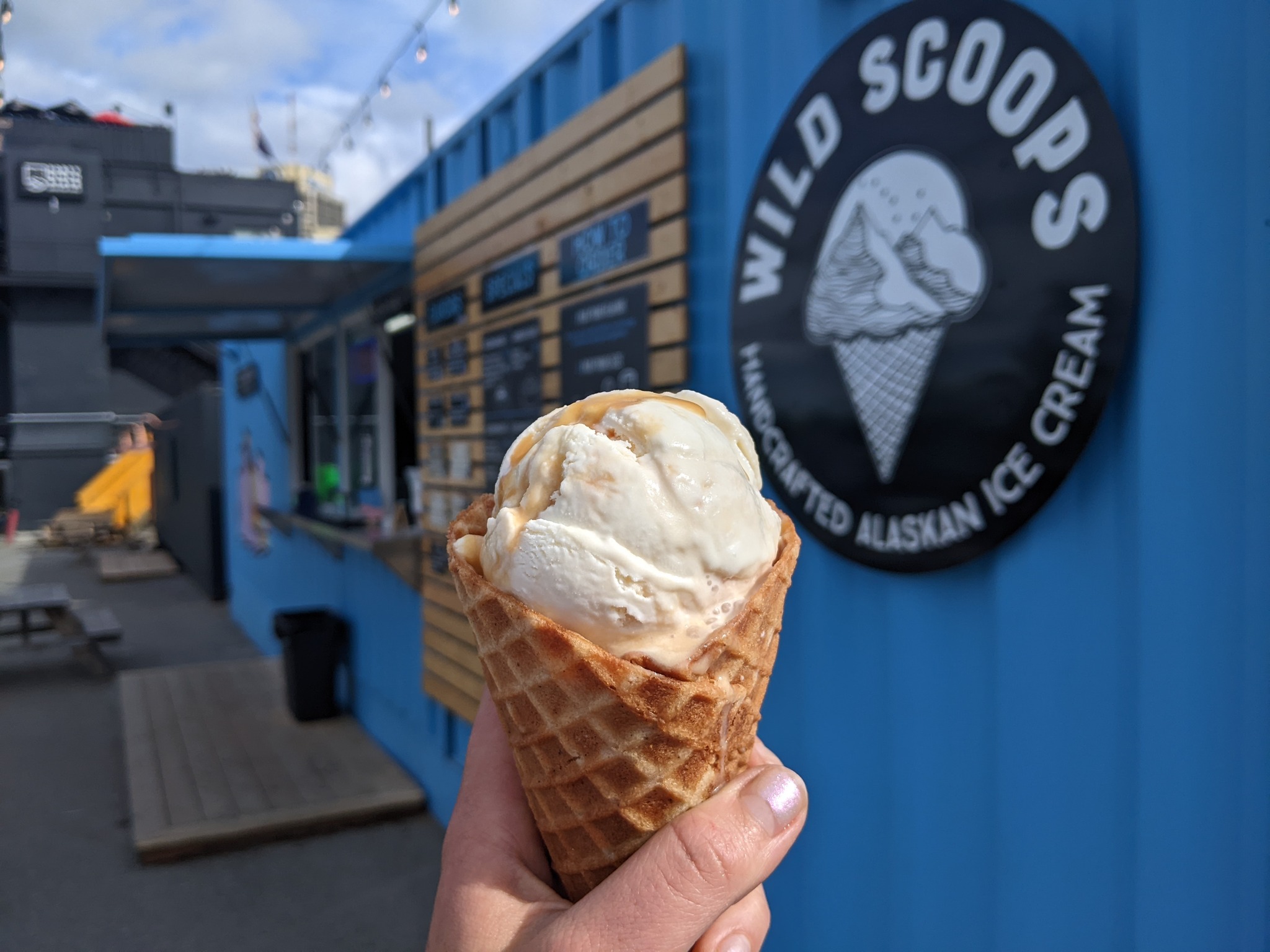 An image of a refreshing ice cream cone from Wild Scoops in front of their new location in the 49th State Brewery Beer Garden
